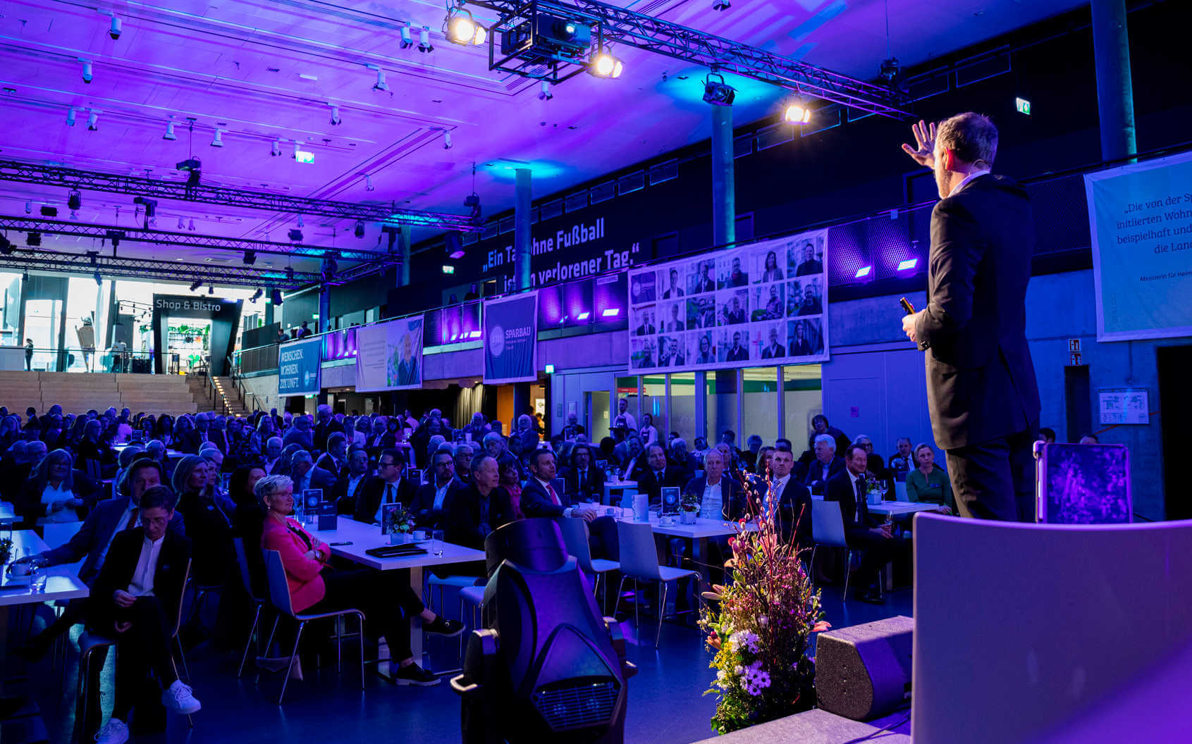 Keynote-Speaker Dr. Nicolas Dierks bei einem Vortrag von hinten zu sehen, wie er das Publikum zum Mitmachen animiert.